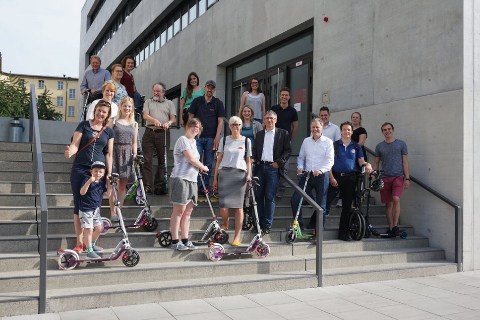 Eine Gruppe von Menschen mit Tretrollern auf einer Treppe