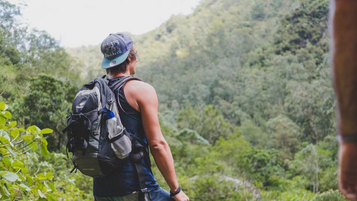 Ein Student mit Rucksack bei einer Wanderung