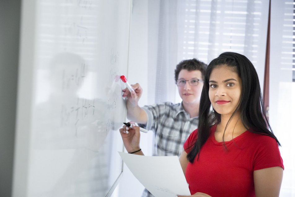 Zwei Studierende schreiben an ein Whiteboard