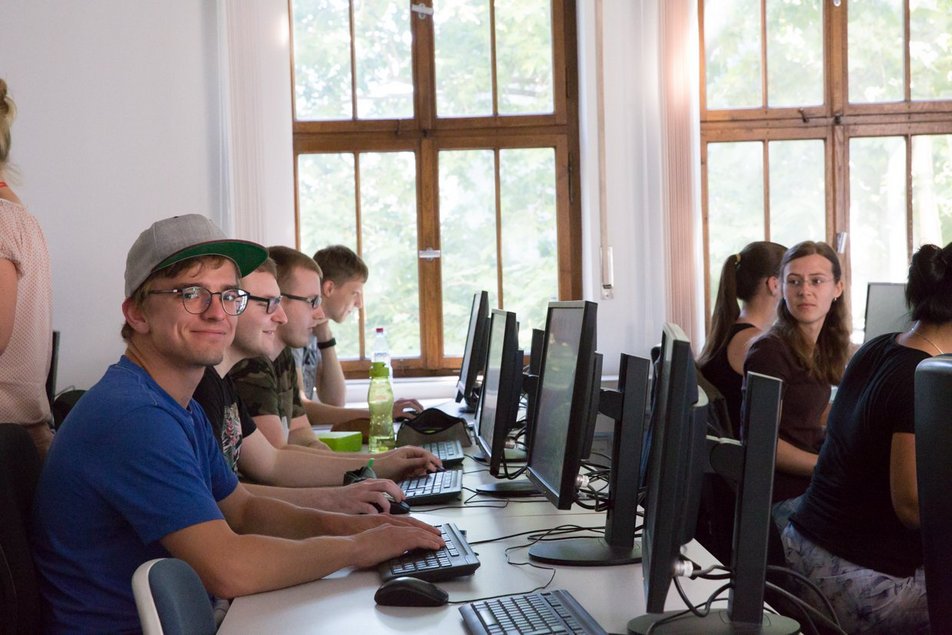 Studenten sitzen vor Computern im PC-Raum